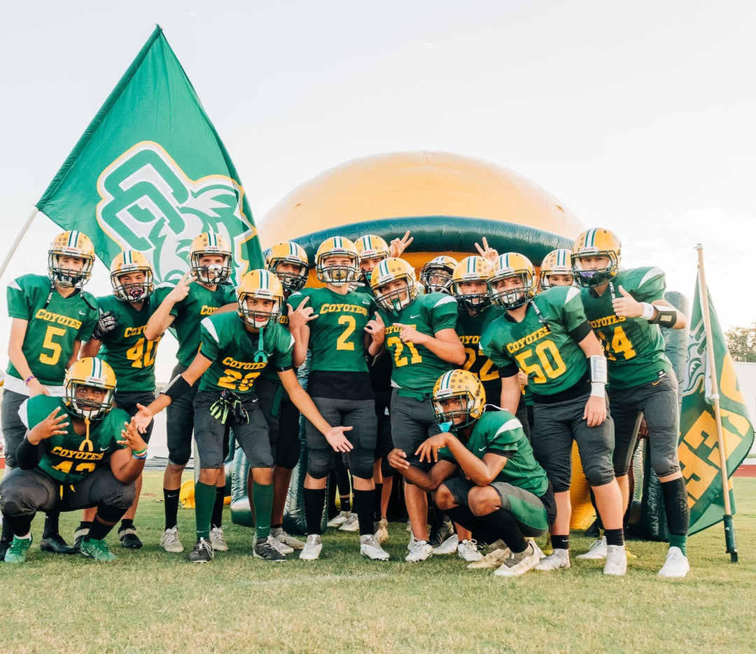 Cypress Creek High School football players posing in front of inflatable helmet tunnel before a game