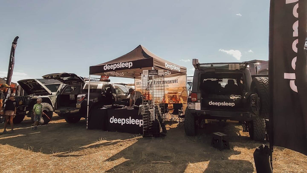 DeepSleep custom canopy tent at off-road expo with Jeep camping gear display and branded booth setup