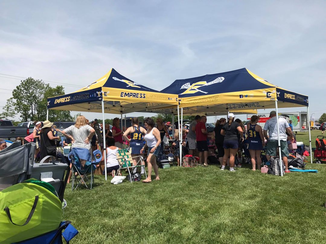 Two custom 10x20 and 10x10 canopy tents for Empress Lacrosse providing team shade during outdoor tournament