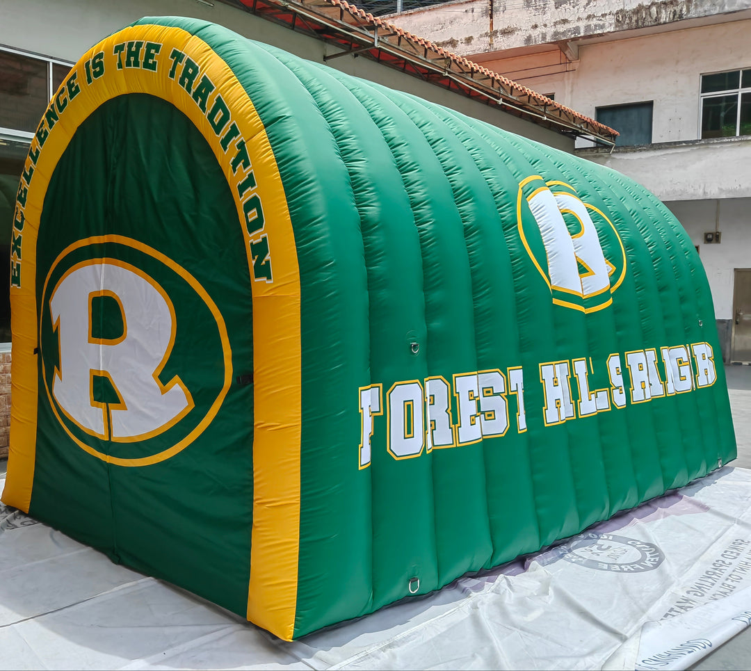 Green and yellow inflatable tunnel with Forest Hills High School logo and “Excellence is the Tradition” slogan