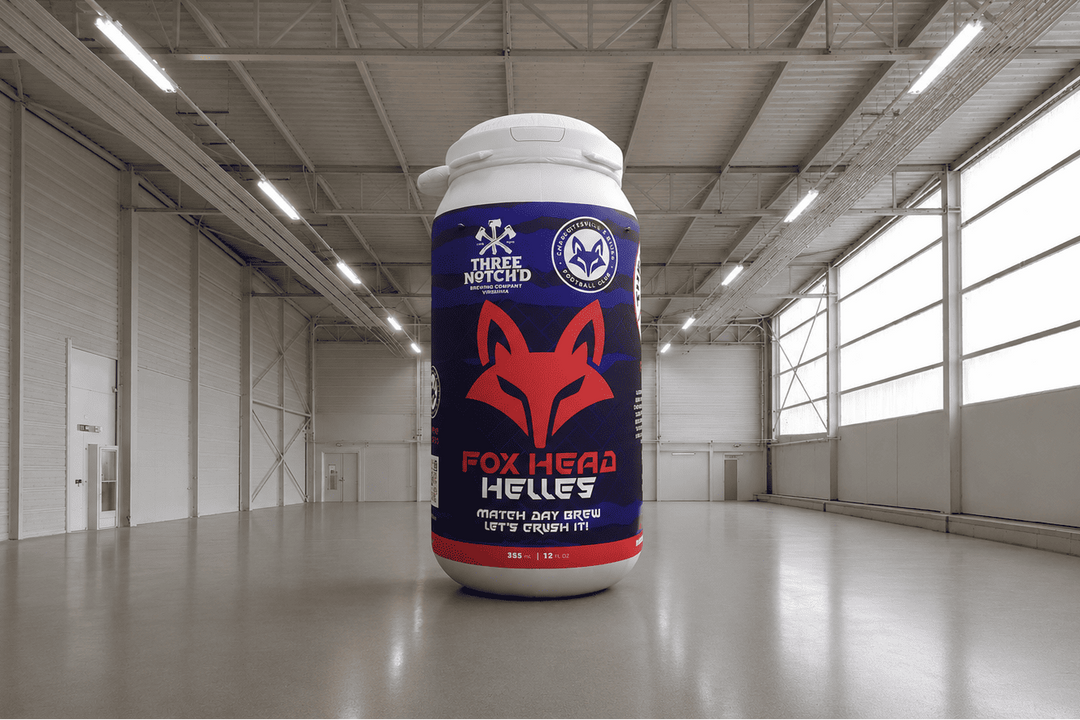 Large inflatable bottle of 'Three Bicycles Fox Head Helles' beer in a warehouse setting