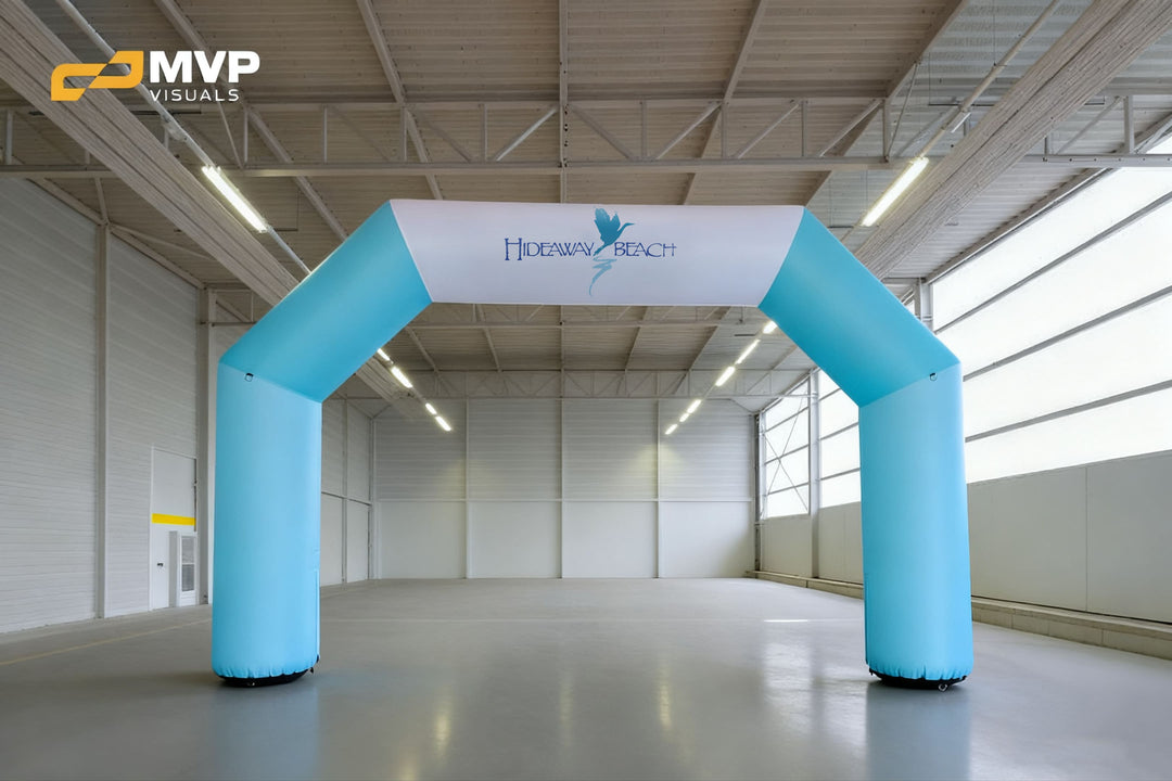 Light blue and white inflatable arch with Hideaway Beach logo in indoor venue