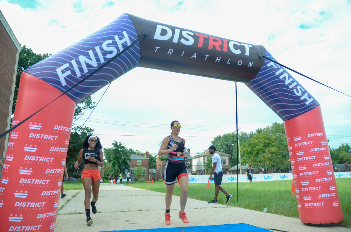 Woman crossing the finish line at a District Triathlon event