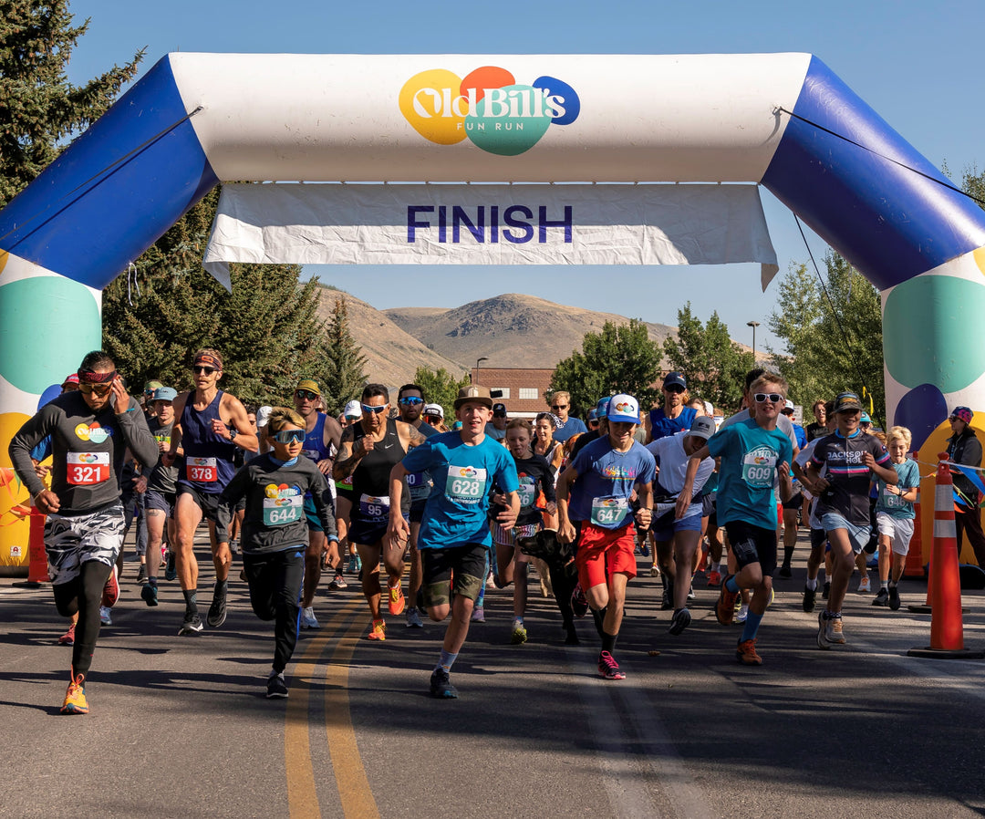 Runners starting a community race under a custom inflatable arch with Old Bill's Fun Run logo at the finish line, provided by MVP Visuals