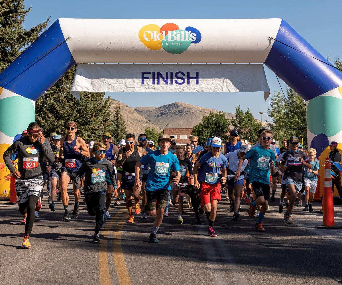 Runners starting a community race under a custom inflatable arch with Old Bill's Fun Run logo at the finish line, provided by MVP Visuals
