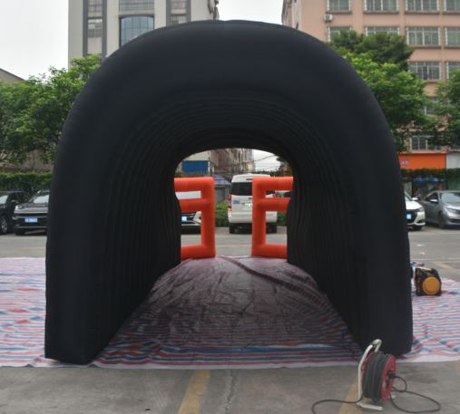 Rear view of black inflatable football helmet tunnel with orange facemask