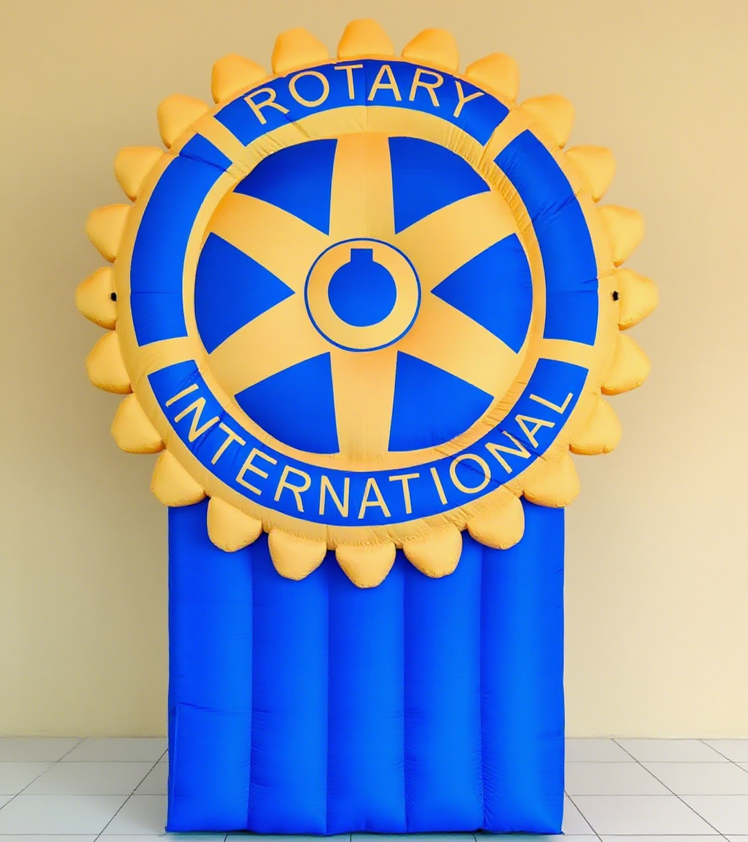 Inflatable Rotary International emblem in yellow and blue against a light-colored wall