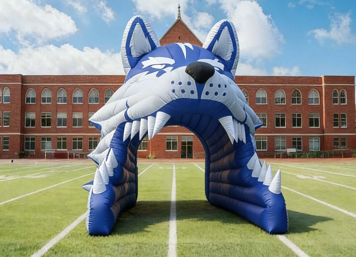 Inflatable arch with wolf design on a sports field, branded 'MVP'.