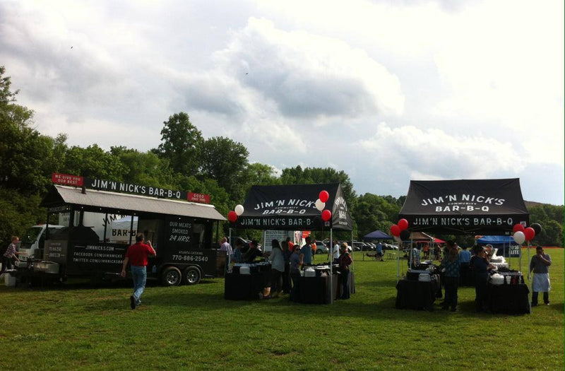 Jim ‘N Nick’s BBQ 10x15 custom canopy tents with food truck and branded booth setup at outdoor event
