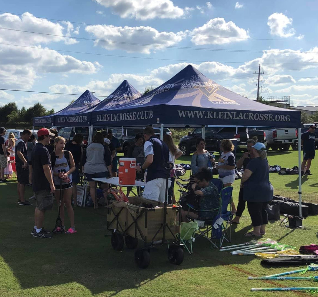 Klein Lacrosse Club tents at sports event with crowd and field setup