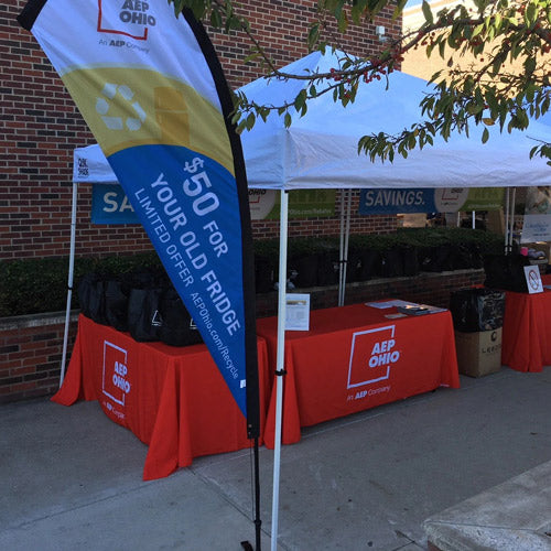 Promotional teardrop feather flag for AEP Ohio's $50 fridge savings offer at an outdoor event booth