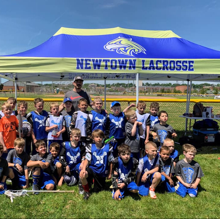 youth lacrosse team under Newtown Lacrosse canopy tent
