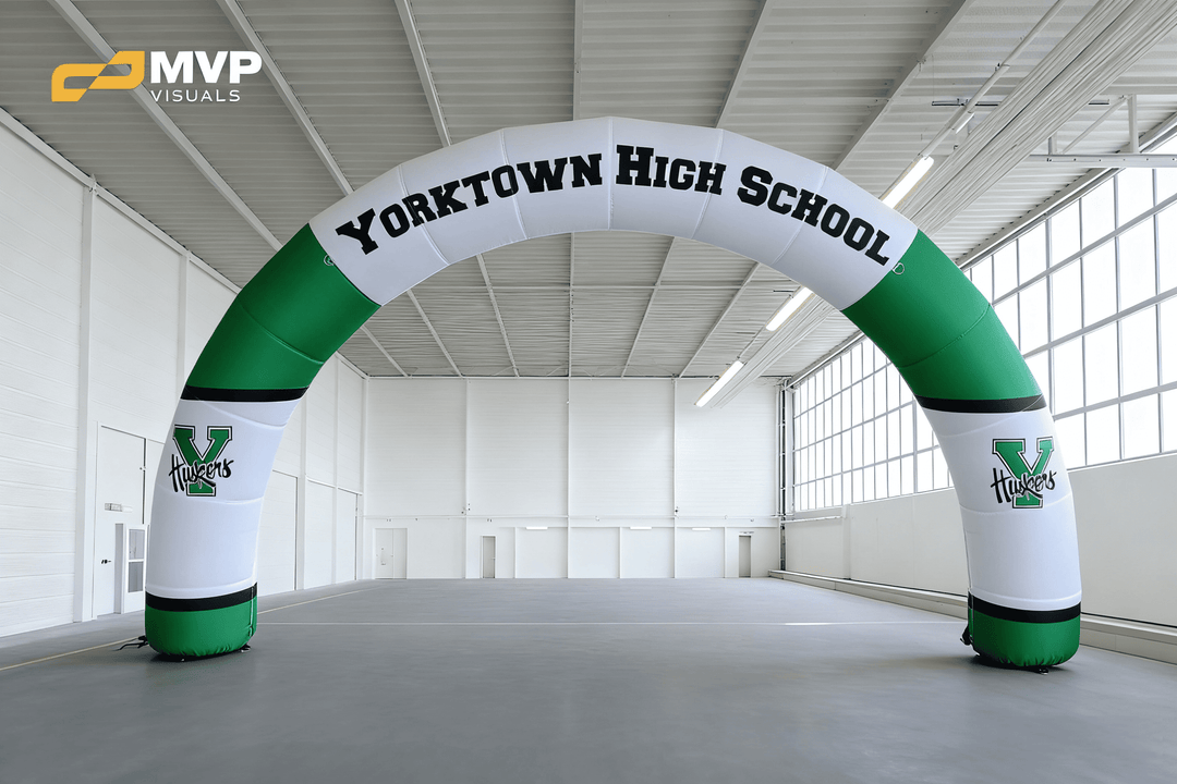 Green and white inflatable arch with Yorktown High School Huskers logo in gymnasium