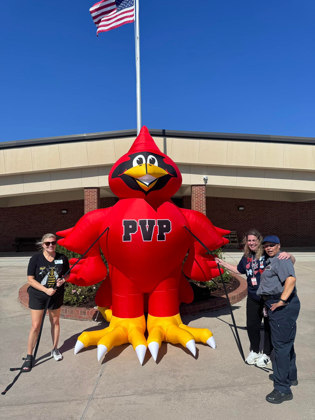 Prairieville mascot inflatable cardinal with PVP letters, displayed in front of school building