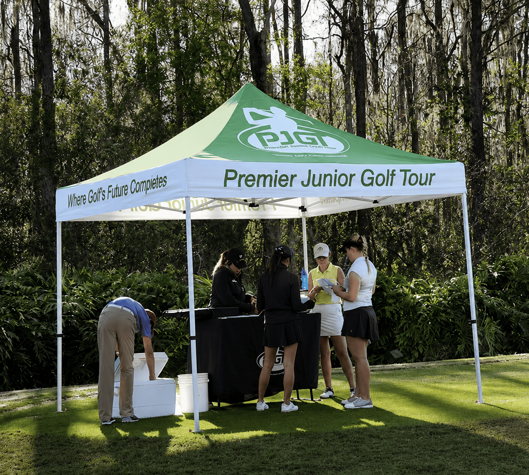 People under a Premier Junior Golf Tour tent on a golf course