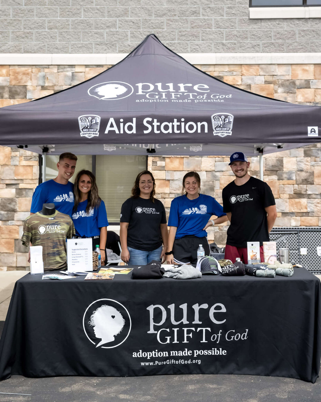 Pure Gift of God custom canopy tent at adoption awareness aid station with volunteers and merchandise booth