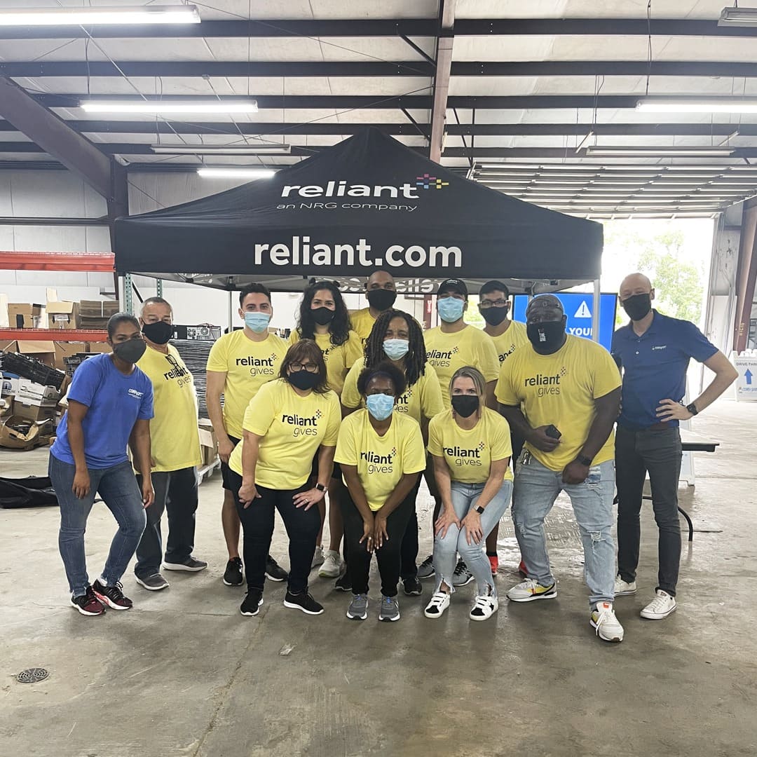 Reliant Energy custom canopy tent at indoor volunteer event with team members wearing branded shirts