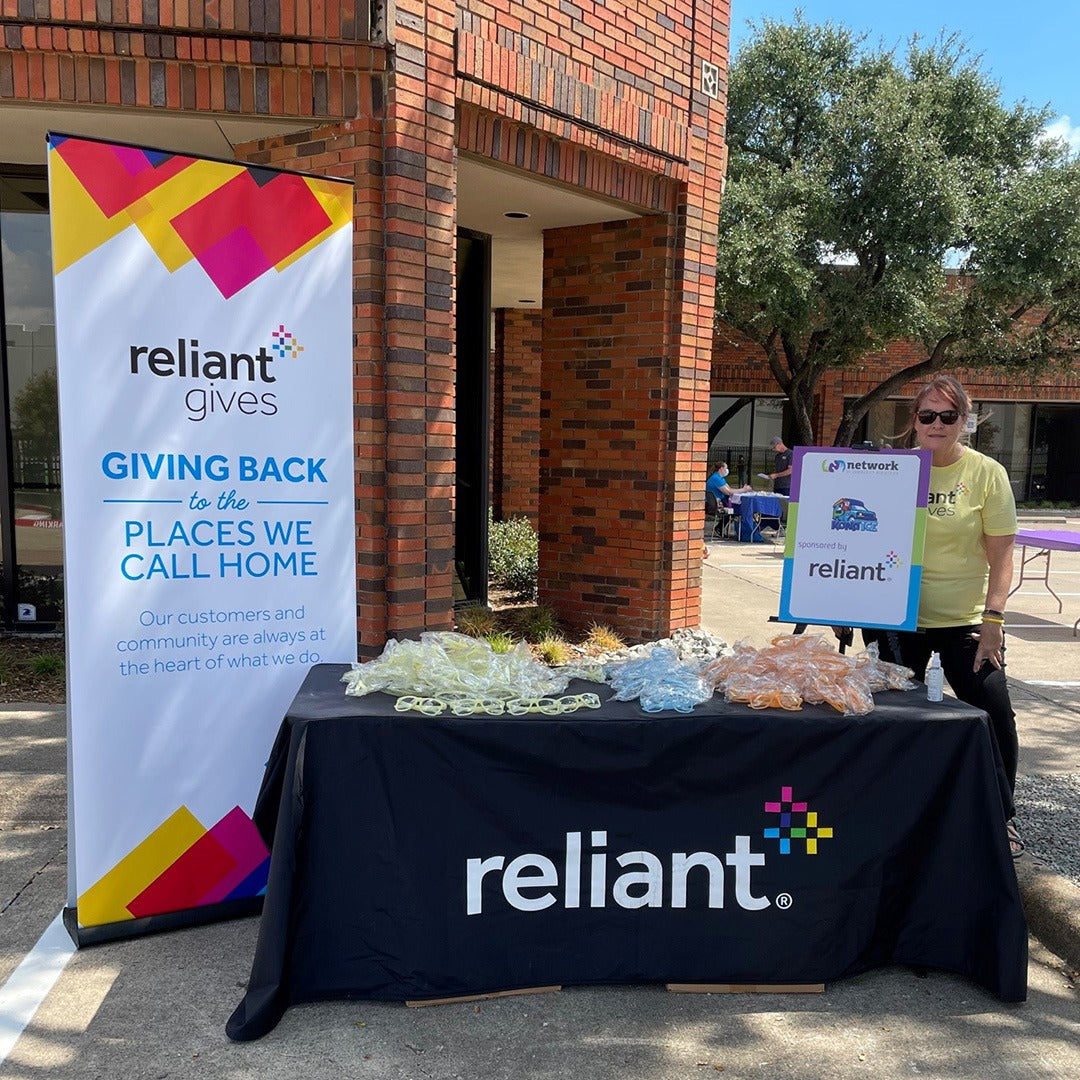 Reliant event with table and banner outside a building
