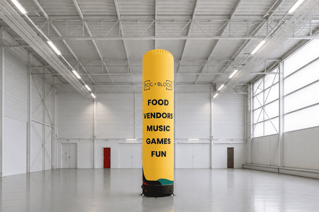 Yellow inflatable tube man in a large warehouse with text on it.