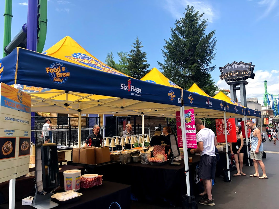 Six Flags Food & Brew Festival branded canopy tents at Gotham City park area