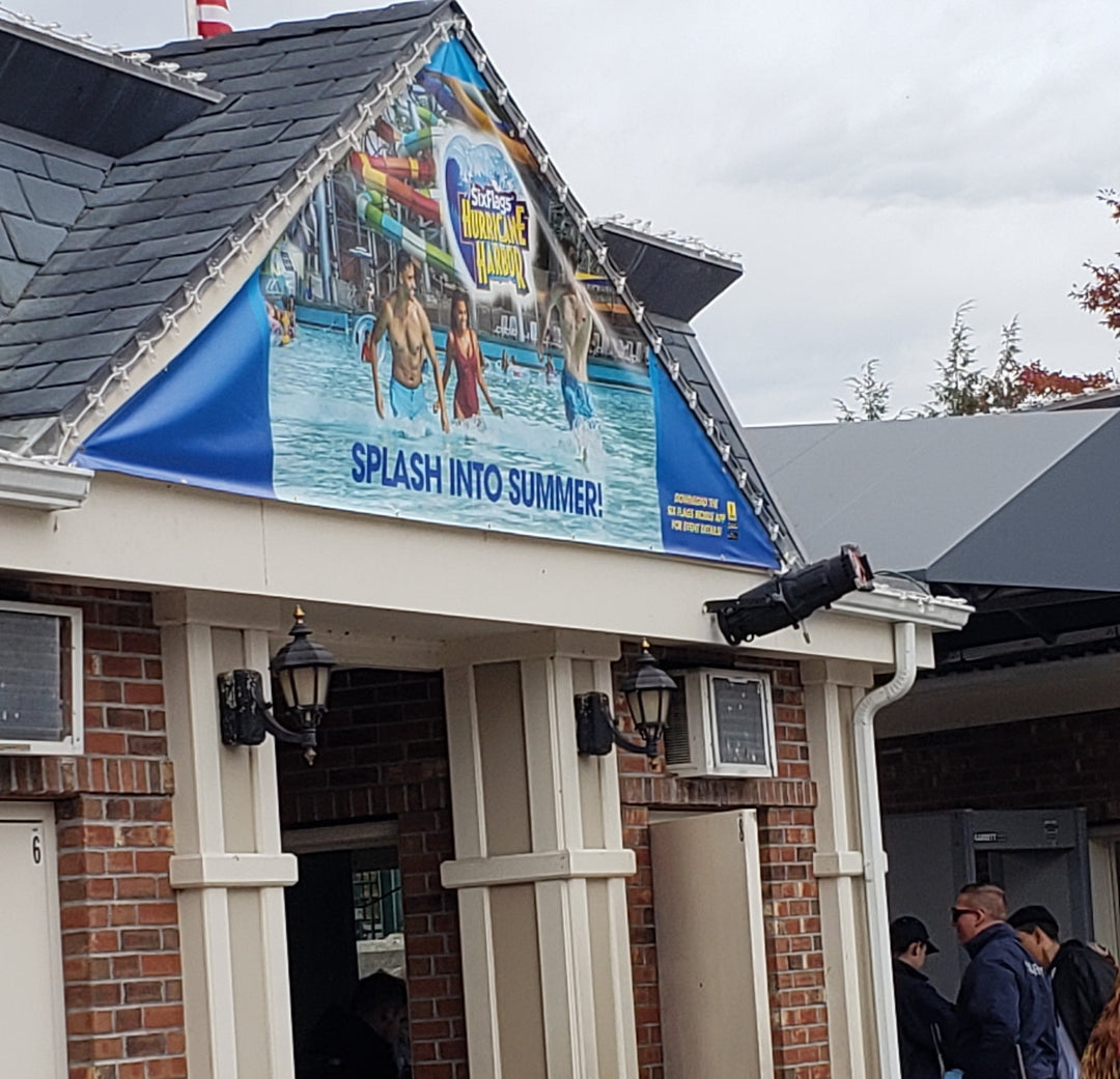 Gable vinyl banner for Six Flags Hurricane Harbor featuring swimmers and colorful water slides with the slogan "Splash Into Summer!"