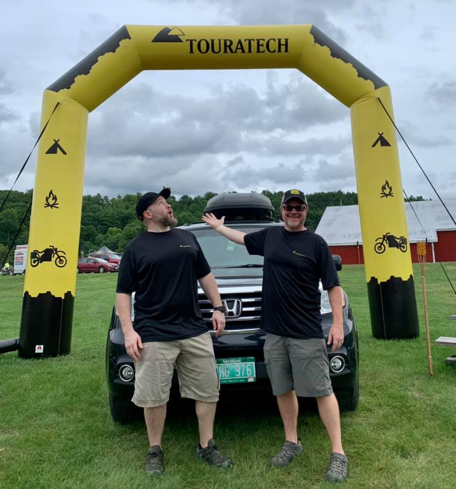 Custom inflatable arch for Touratech USA with yellow and black mountain design and adventure icons