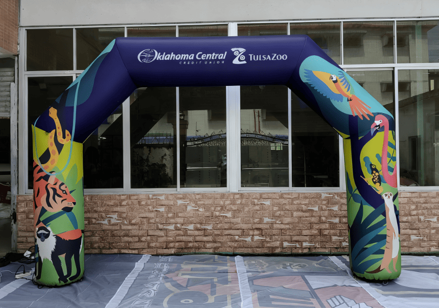 Jungle-themed inflatable arch featuring Oklahoma Central Credit Union and Tulsa Zoo logos with illustrated animals