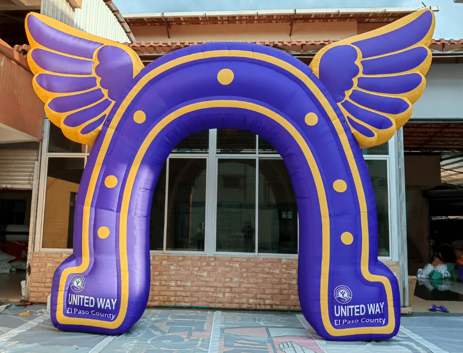 Purple inflatable arch with gold wings and horseshoe design for United Way El Paso County