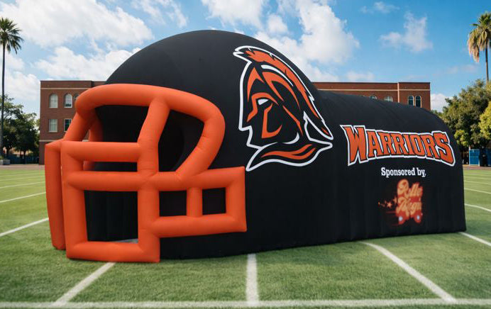 Inflatable sports tunnel with warrior logo on a football field