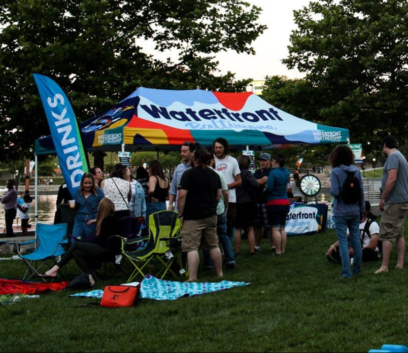 community event with Waterfront Partnership canopy and families on grass
