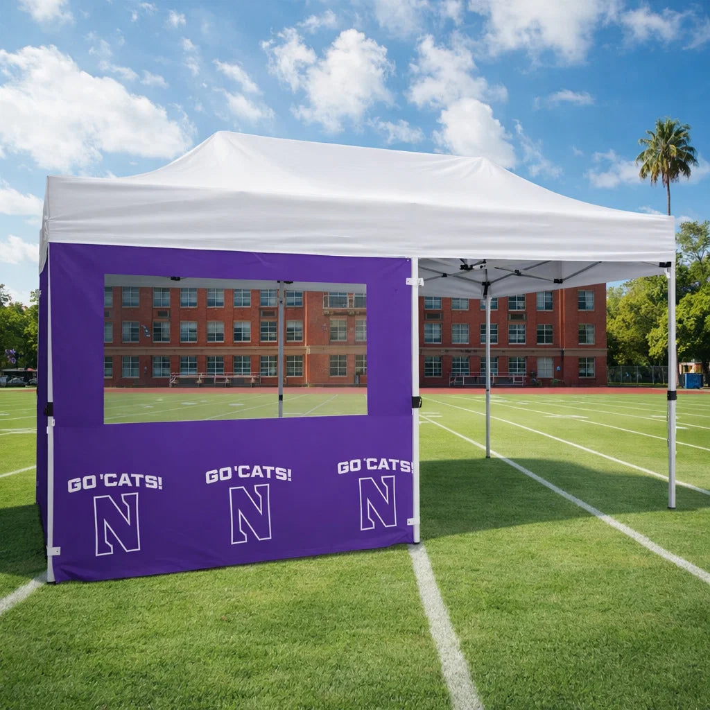 White canopy tent with purple side panel featuring 'GO CATS!' and 'N' logo on a sports field.