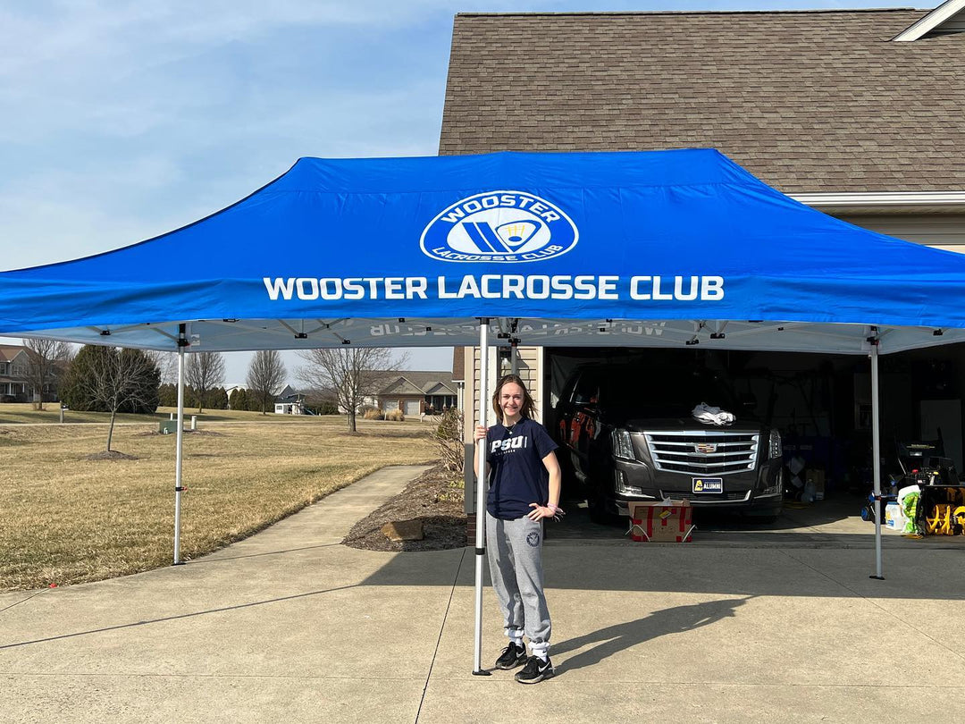 Wooster Lacrosse Club custom canopy tent set up in suburban driveway with athlete standing in front