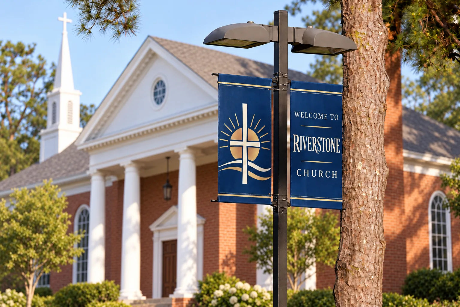 Paired blue welcome banners mounted on a light pole outside a church